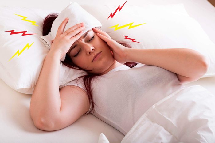 woman with headache in bed
