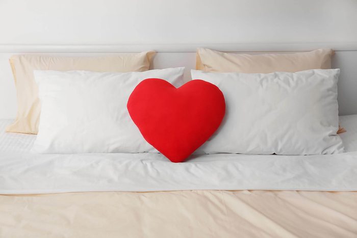 red heart pillow on bed