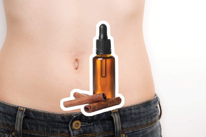 Cinnamon oil over a woman's bare abdomen