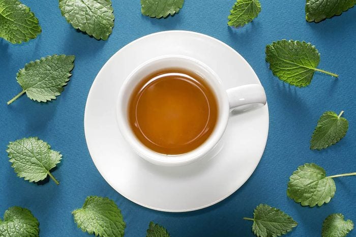 cup and saucer of tea with mint leaves