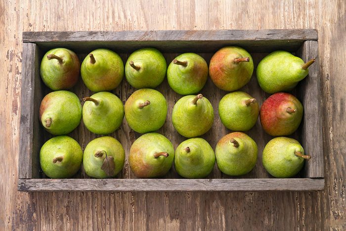 pears in a wooden crate on wooden surface