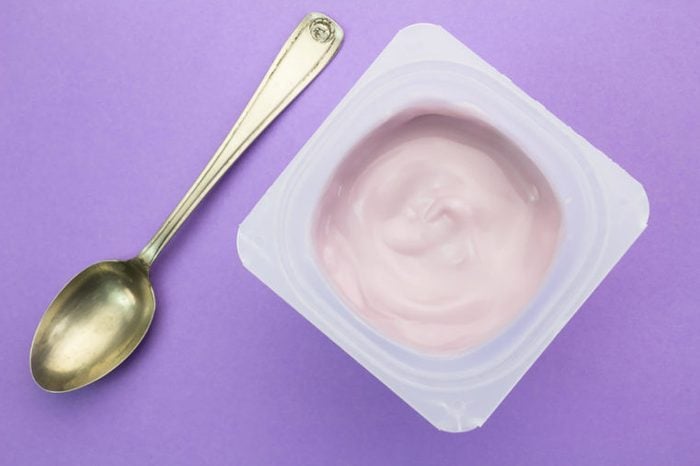 container of strawberry yogurt with spoon