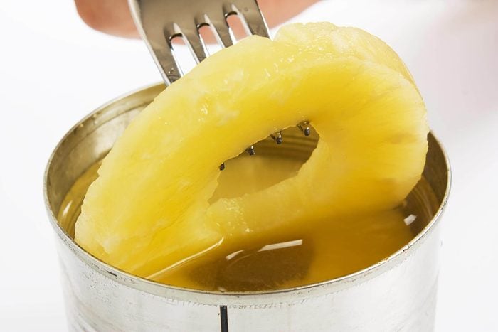 canned pineapple ring being lifted with a fork