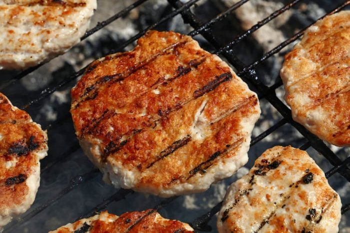 Chicken or turkey poultry meat barbecue grilled burgers for hamburger prepared on bbq smoke grill, close up