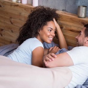 Sweet couple talking in bed on their honeymoon