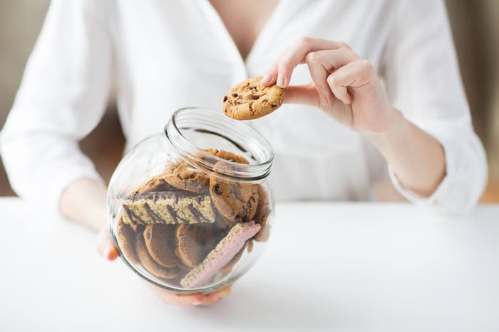 woman holding glass jar of cookies