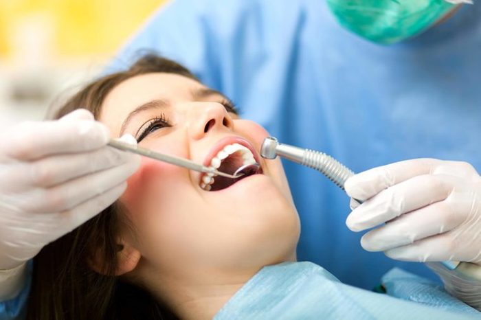 Dentist examining a female patient's mouth