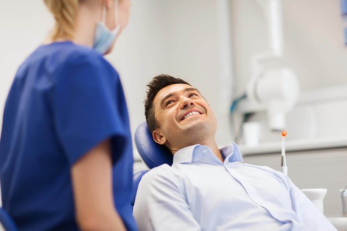 patient in dental chair smiling at Dentist