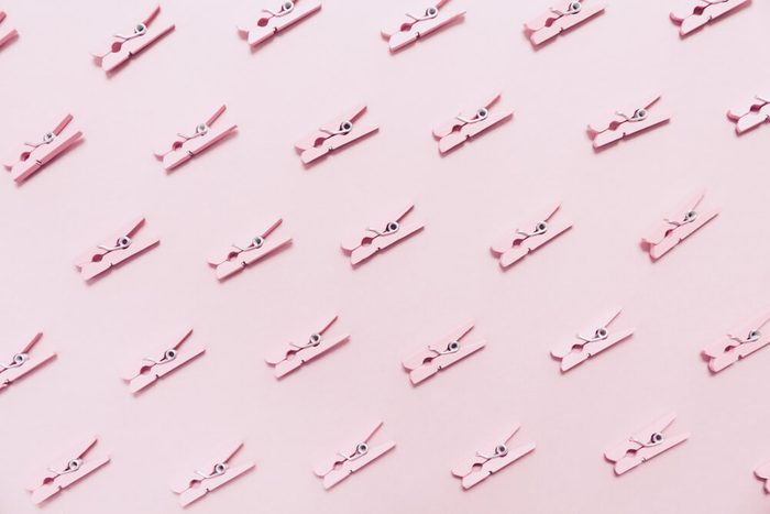Pink clothes pins on the pink background. Horizontal