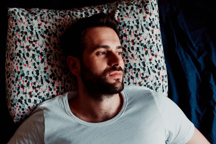 man lying in bed not able to sleep
