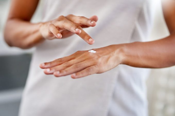 woman applying moisturiser to her hands psoriasis skin remedy