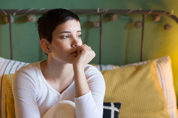 young woman sitting in bed not able to sleep