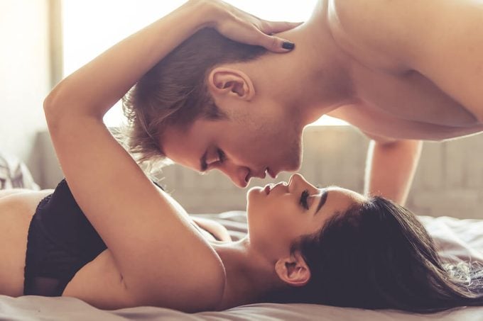 Sensual young couple about to kiss on bed