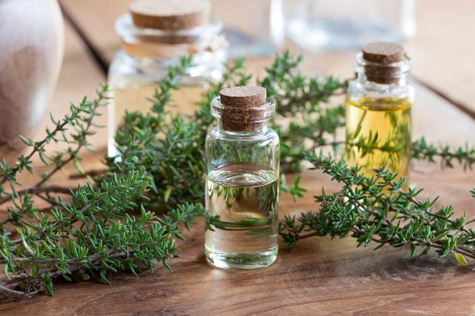 Essential oils, herbs, glass bottles on a wood table