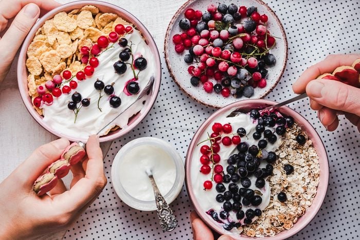 bowls of yogurt, berries, and cereal