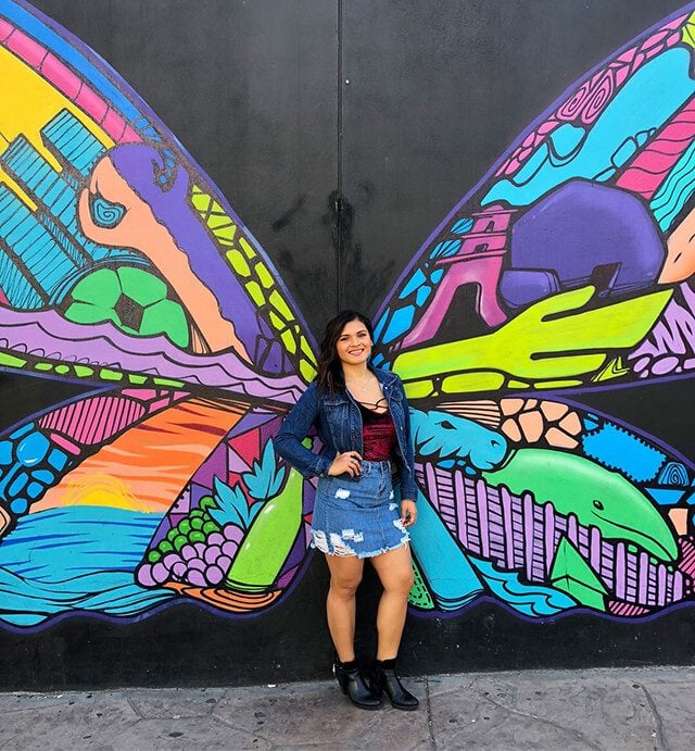 Laura Gonzlaez in front of colorful butterfly wings