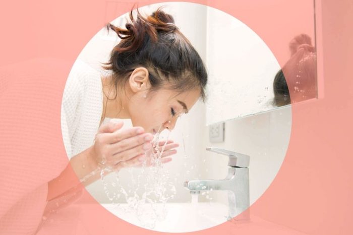 woman washing her face in the sink