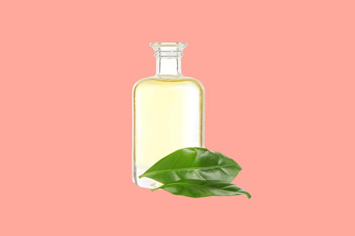bottle of tea tree oil with leaves