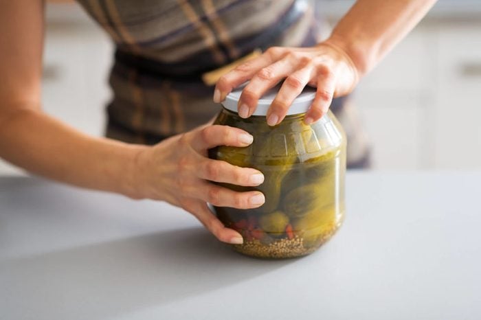 Woman opening pickle jar