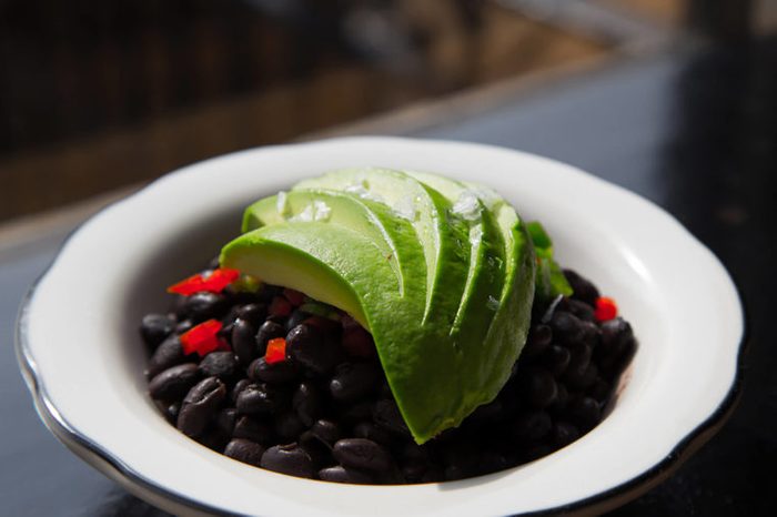 Black bean bowl topped with avocado slices.