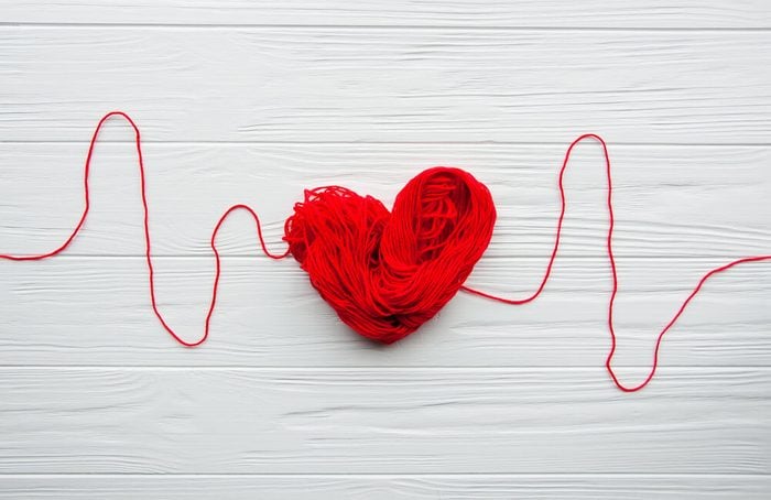Heart and cardiogram made of red thread.