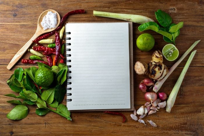 empty journal surrounded by garlic, spices and herbs