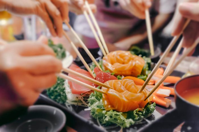 people eating sashimi set in Asian restaurant