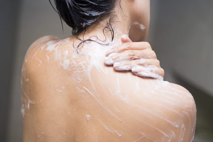young woman washing her body with shower gel, healthcare