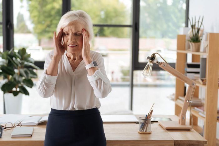 Sad elderly woman suffering from migraine
