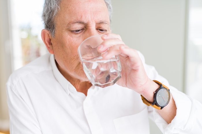 man drinking a glass of water