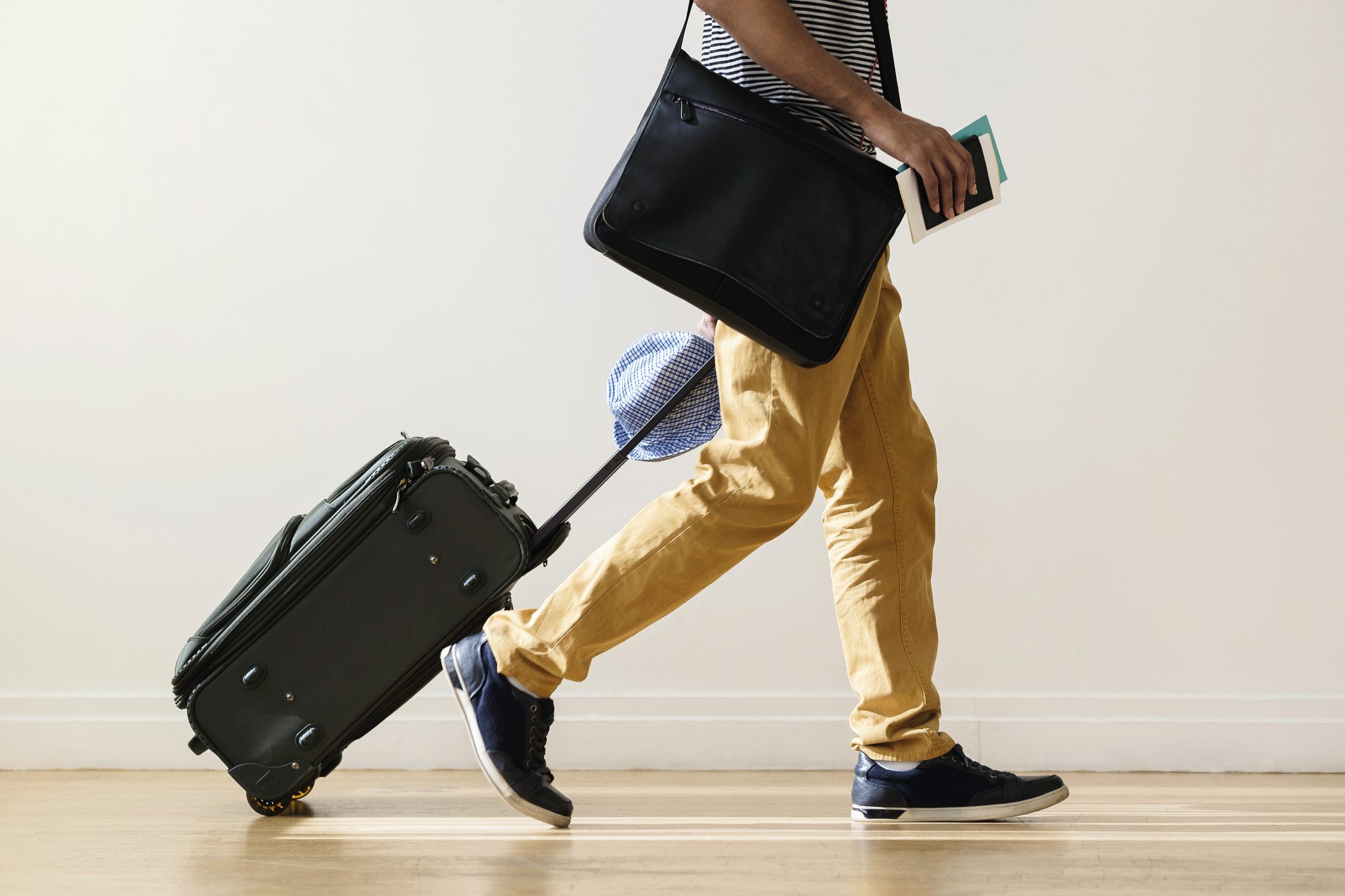cropped shot of man traveling holding suitcase and passport