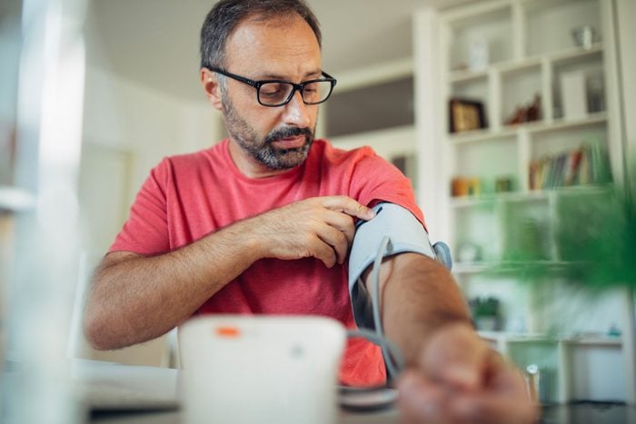 man checking his blood pressure at home