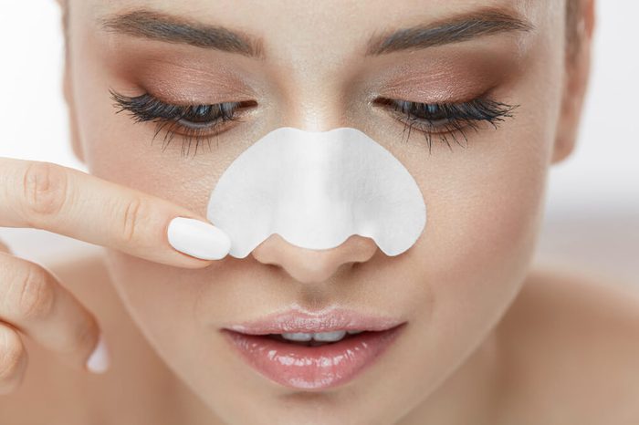 Woman using a pore strip on her nose