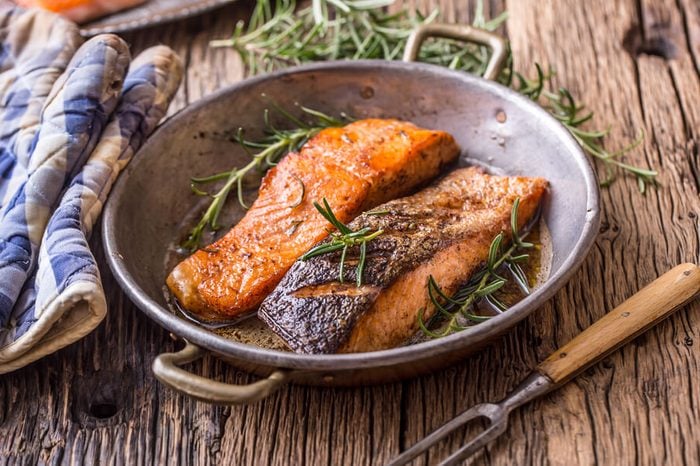 Cooked salmon fillets with rosemary in pan