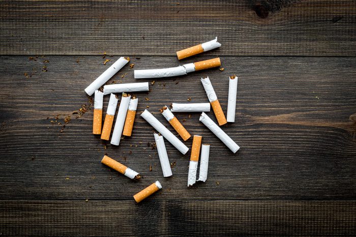 Scattered cigarettes on dark wooden background