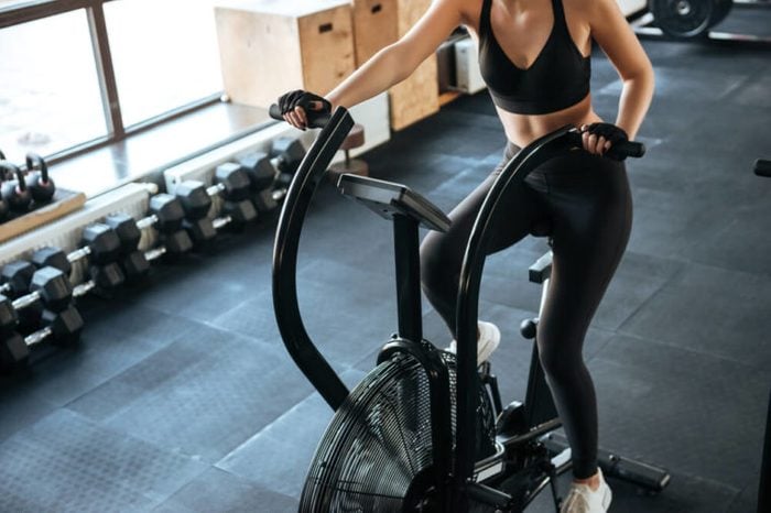 Woman on spinning bicycle at gym.