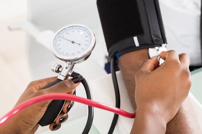Close-up Of Doctor Measuring Patients Blood Pressure With Stethoscope
