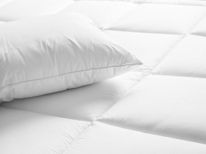 Closeup of white pillow on the bed in the bedroom