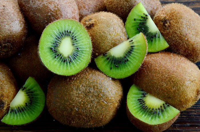 A lot of fresh Kiwi fruits on wooden floor.Kiwis are a nutrient dense food, they are high in nutrients and low in calories.