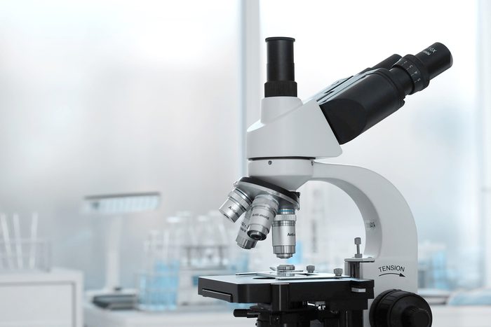 Laboratory lens of Microscope Isolated blue scientific research background