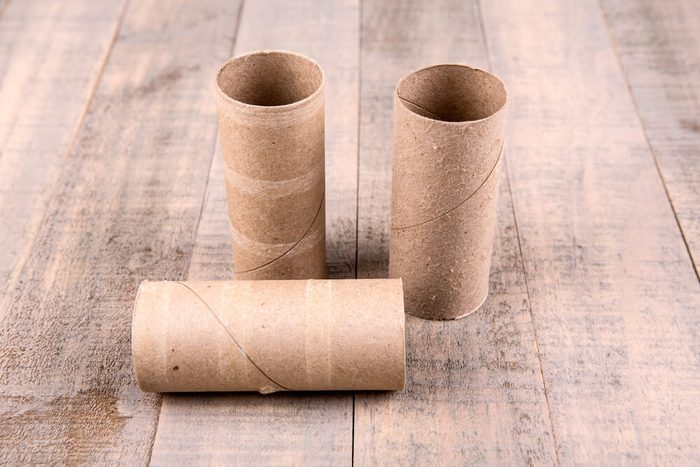 Three empty toilet paper rolls isolated on a wood background
