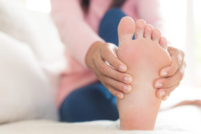 close up of woman holding foot