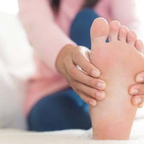 close up of woman holding foot