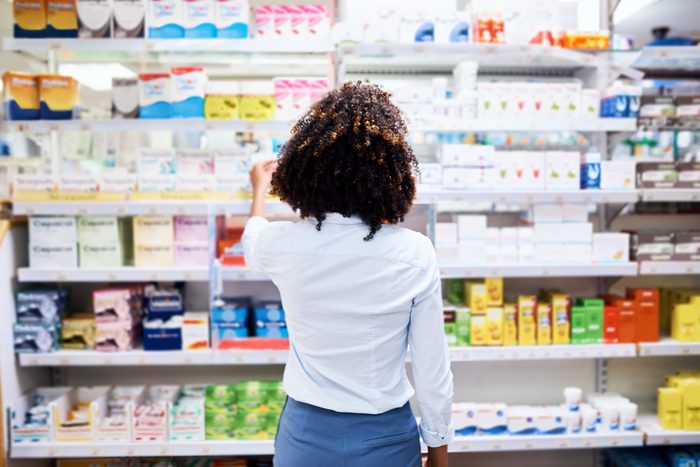 woman in drug store picking out medication to buy