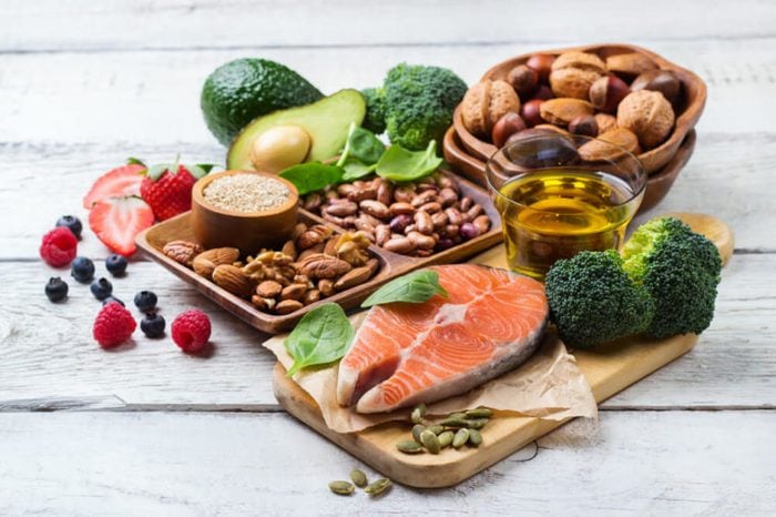 display of heart-healthy foods: salmon, fruit, veggies, olive oil, and nuts 