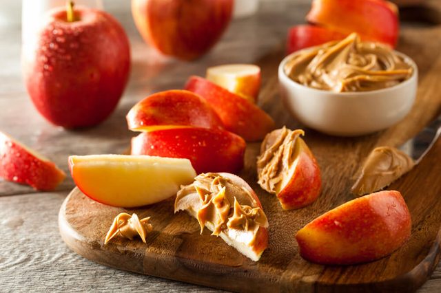 sliced and whole apples with peanut butter