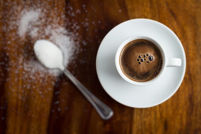 Xícara de café com açúcar na mesa de madeira