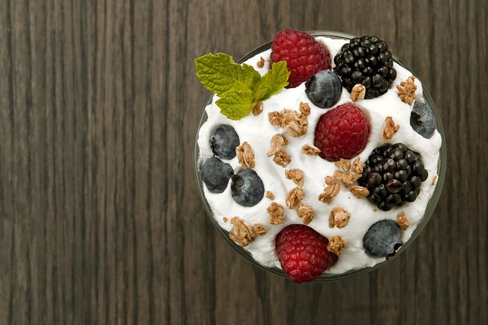 Yogurt parfait with fresh berries and a mint leaf