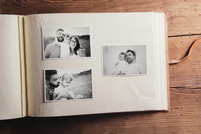 Fathers day composition - photo album with a black and white photos. Studio shot on wooden background.