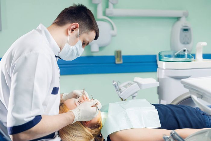 Male dentist and female patient in a dentist office. Taking a closer look